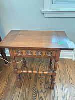 Side table closed showing carved apron and turned legs