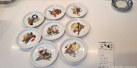 Eight Winterling Mühlbach porcelain saucers with assorted food motifs displayed front view, measurement tag showing 3.5 in
