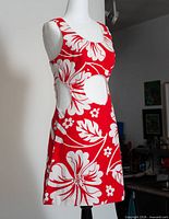 Full side view of red and white floral mini dress on mannequin showing side cut-out