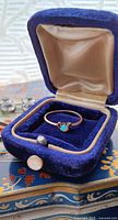 Ring in blue velvet box showing front view and opal stone