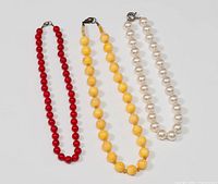 Three necklaces laid flat showing full length and bead styles