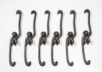 Six identical cast iron monkey hooks displayed flat