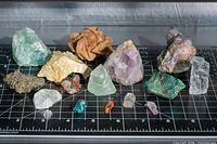 All mineral specimens laid out on grid mat, overview of lot