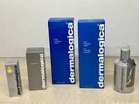 All five Dermalogica products standing: serum box, precleanse box, two body cream boxes, pump bottle body cream