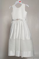 Front view of white satin youth dress with sash and lace bands