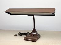 Front view of brown adjustable desk lamp showing shade and base