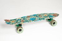 Side view of floral print Globe Bantam cruiser skateboard showing deck graphic and full hardware