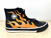 Left side view of sneaker showing flame graphics and ankle logo patch