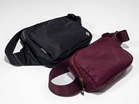 Black and burgundy Lululemon belt bags front view