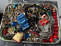 Tray overflowing with assorted jewelry pieces