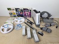 Full bundle layout including console, cables, controllers, wheels, sensor bars, Wii Speak and game cases