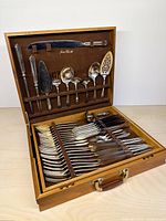 Open chest showing upper utensil rack and lower tier with flatware rows