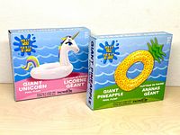 Front of two boxed Incrediflate giant pool floats (unicorn and pineapple)