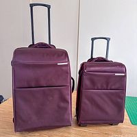 Front view of both burgundy Samsonite suitcases with handles extended