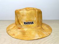 Front view of yellow chip-print bucket hat with embroidered Tostitos logo