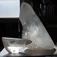 Large clear quartz and smaller smoky quartz crystals side by side