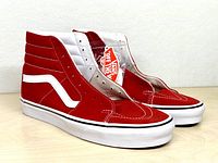 Side view of both red Vans Sk8-Hi sneakers with hangtag