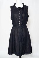 Front view of black sleeveless dress showing buttons, belt, overall style