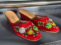 Both red satin wedge mules side by side