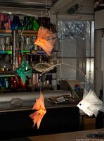 mobile hanging over workspace showing four fish and wire structure