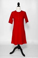 Full view of red cotton dress on mannequin showing overall style