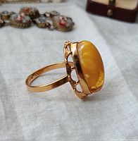 Side view of gilt ring showing openwork gallery and amber cabochon