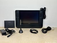 Front view of Wacom Cintiq 12WX tablet with pen, stand, interface box, power adapter and cables