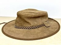 Front/side view of tan suede Outback hat with braided hatband and brim