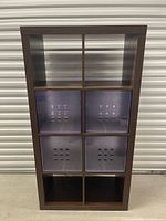 Front view of brown IKEA Kallax shelf with four purple bins inserted