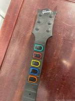 Headstock and colored fret buttons on neck