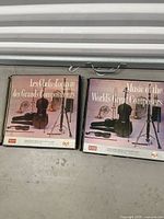 Two vinyl record box sets side by side showing English and French titles