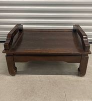 Front view of low wood table showing handles and legs