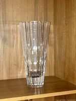Full view of clear crystal vase on shelf