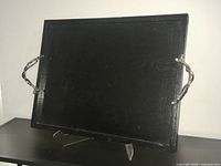 Full view of black wooden serving tray on stand