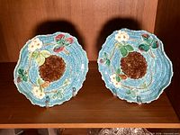 Pair of turquoise majolica plates on stand showing overall condition