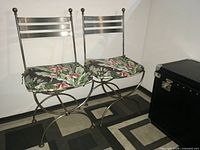 Pair of wrought iron side chairs showing overall form and cushions
