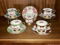 Group shot of five Shelley cup and saucer sets on shelf