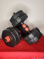 Two adjustable dumbbells assembled with black vinyl plates and red collars