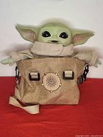 Grogu plush seated inside tan satchel showing overall appearance