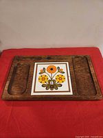 front of wooden serving board showing tile insert and recessed wells