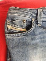 Close-up of coin pocket showing Diesel Industry label and denim texture