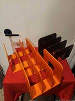 All three magazine racks grouped together showing two orange and one brown