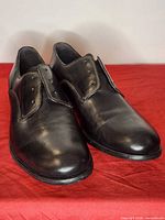 Pair of black leather John Varvatos Derby shoes angled view