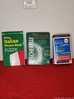 Front covers of three language reference books on red surface