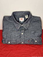 Folded Levi's blue denim western shirt with pearl snaps