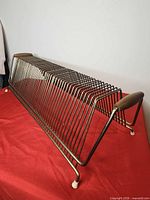 Side view of metal wire record holder rack showing angled design and wood handle