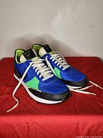 Oblique view of both sneakers showing lateral sides, colors, laces, outsole.