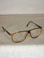 Front angled view of golden and maroon Playboy frames with demo lenses
