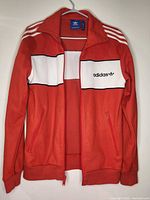 Front view of Adidas red track jacket open
