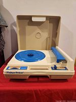 Record player open showing platter and tone arm